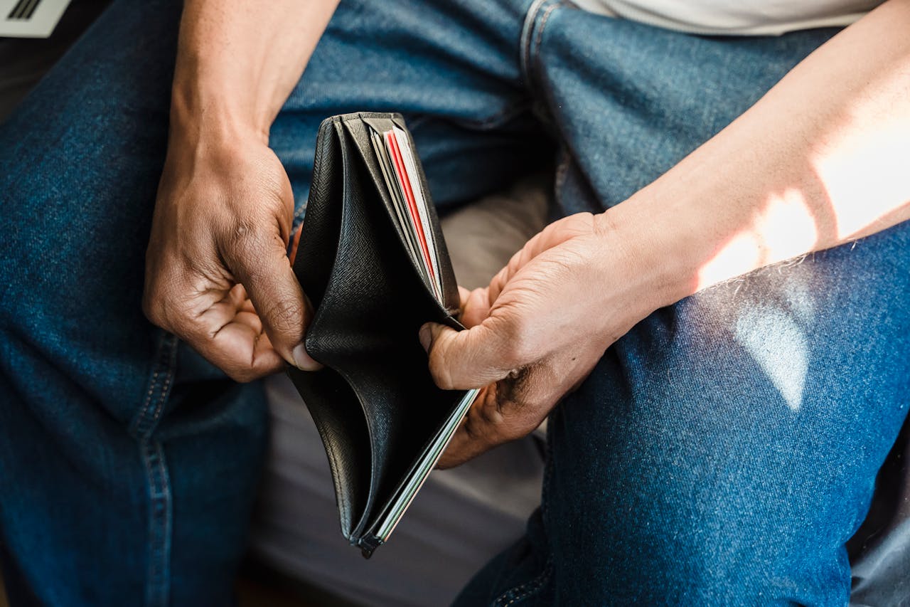 services-01 Close-up of a man holding an empty wallet, symbolizing financial crisis and hardship.